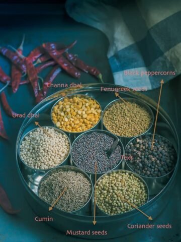 Essential South Indian spice ingredients displayed in an Indian spice rack called anjaraipetti.